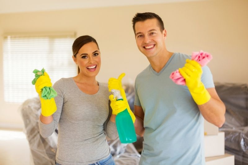 happy cleaners with gloves and cleaning sprays