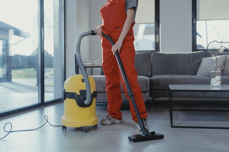 vacuuming the floor for a clean and dust-free cleaning services