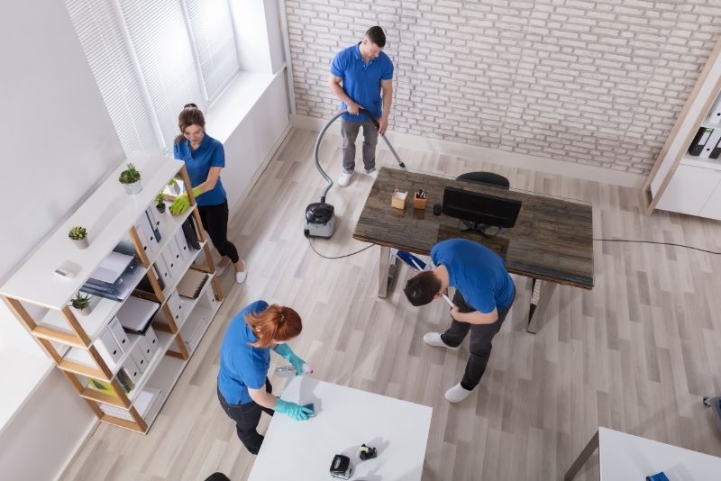 4 cleaners in blue shirt doing office cleaning services